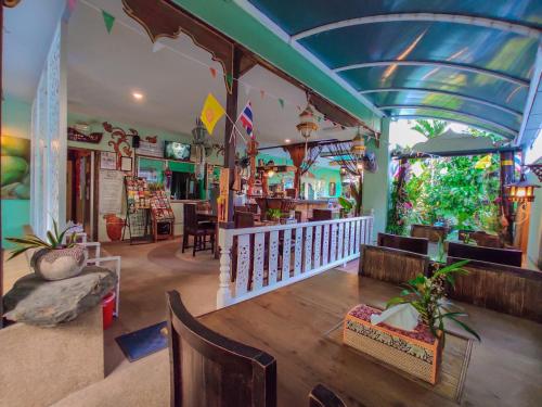 a restaurant with a blue ceiling and tables and chairs at Awana House in Chiang Mai