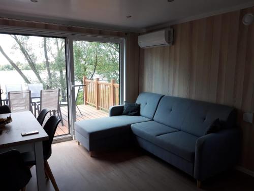 a living room with a blue couch and a table at GARDENIA RAJGRÓD in Rajgród