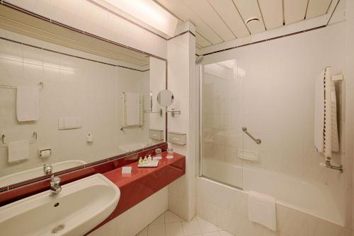 y baño con lavabo, bañera y espejo. en NH Ancona, en Ancona