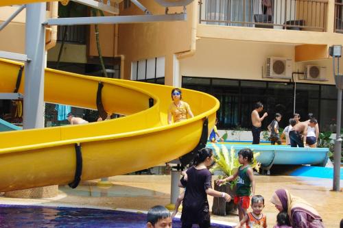 een groep kinderen die in een gele boot op een waterpark spelen bij Gold Coast Morib Resort Apartment Ezzy in Kampong Tanjong Pechah
