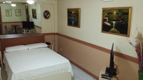 a room with a bed and a tv in it at Kokomos Hotel and Restaurant in Angeles