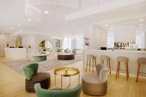 a lobby with a bar with chairs and a counter at NH Trento in Trento