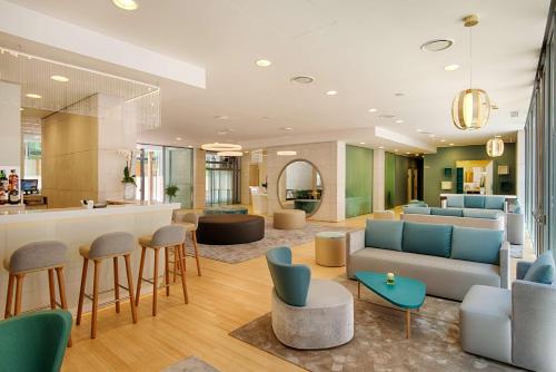 a living room with a couch and chairs at NH Trento in Trento