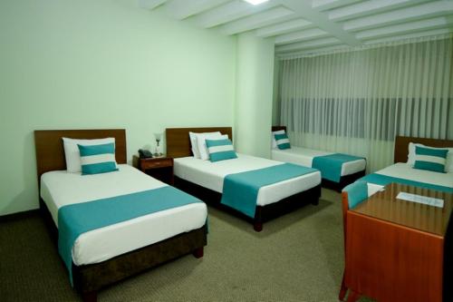 Zimmer mit 2 Betten und einer Kommode in der Unterkunft Hotel Alpamayo Cajamarca in Cajamarca