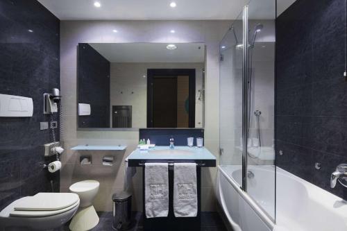 uma casa de banho com um lavatório, um WC e uma banheira em NH Venezia Laguna Palace em Mestre