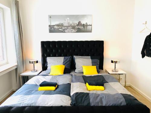 a bedroom with a large bed with yellow pillows at City Center Apartments Düsseldorf in Düsseldorf