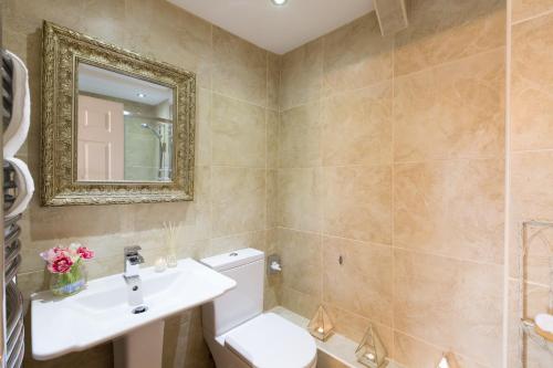 a bathroom with a toilet and a sink and a mirror at Warkworth House Hotel in Warkworth