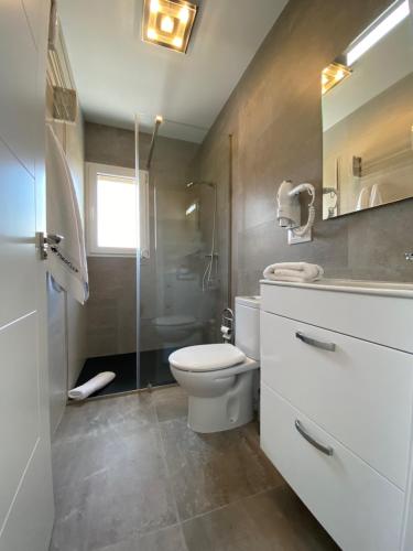 a bathroom with a toilet and a glass shower at Villa Valeria in Oliva