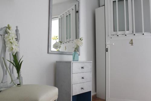 a bedroom with a white dresser and a mirror at H Juan in Marbella