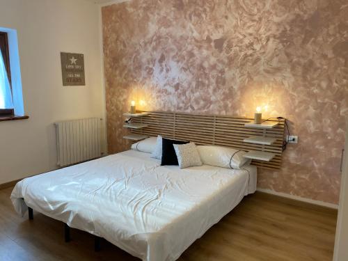 a bedroom with a white bed with two pillows at Casa Belvedere in Pieve di Cadore