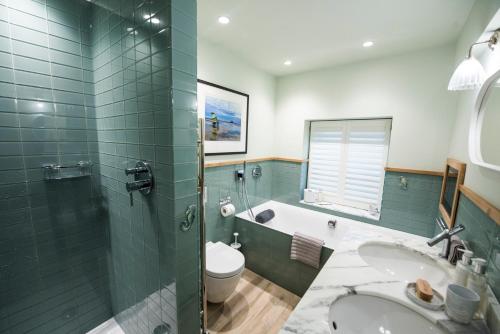 a bathroom with a tub and a toilet and a sink at Iris 5 Star Gold Award Luxury Cottage in St Ives
