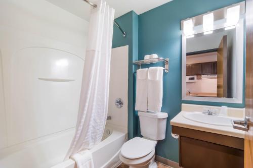 a bathroom with a toilet and a sink and a mirror at WoodSpring Suites Nashville Airport in Nashville
