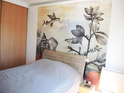 une chambre avec un lit avec un tableau sur le mur dans l'établissement 2 Pièces avec Balcon Plein Sud, à Paris