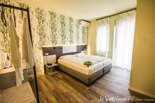 a bedroom with a bed and a large window at Hotel Eden in Torri del Benaco