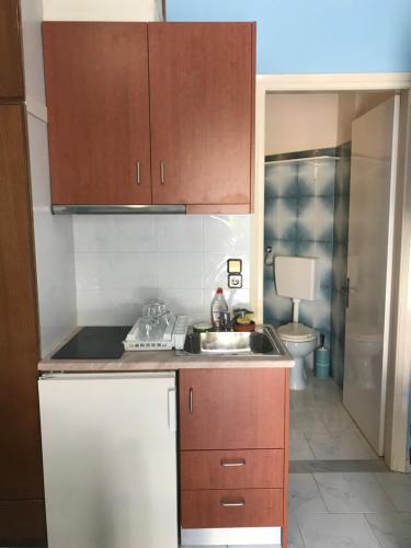 a small kitchen with a sink and a toilet at Vrachos Holidays Hotel in Paralia Vrachou