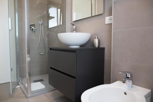 a bathroom with a sink and a toilet and a shower at Venezia Fly Apartments in Tessera