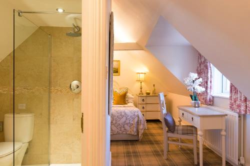 ein Bad im Dachgeschoss mit einer Dusche und einem Bett in der Unterkunft Warkworth House Hotel in Warkworth
