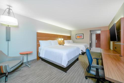 a hotel room with two beds and a television at Holiday Inn Express Hotel & Suites Tappahannock by IHG in Tappahannock