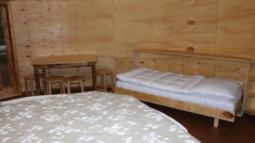 a room with two beds and a table and a bed at Glamp V Hluboké - Yurts and Wooden Houses in Vsetín