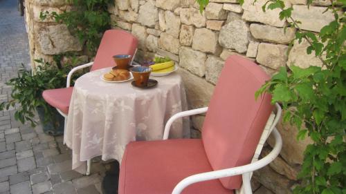 a table with two pink chairs and a white table with at Viola in Skradin