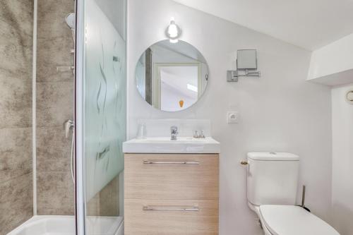 a bathroom with a toilet and a sink and a mirror at Hôtel des Voyageurs Centre Bastide in Bordeaux