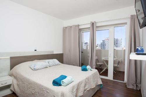 Un dormitorio con una cama con toallas azules. en CPR 1104 en Portimão