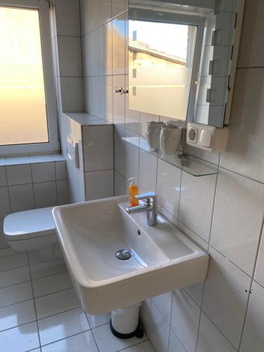 a white bathroom with a sink and a toilet at Zur Sonnenblume in Gangelt