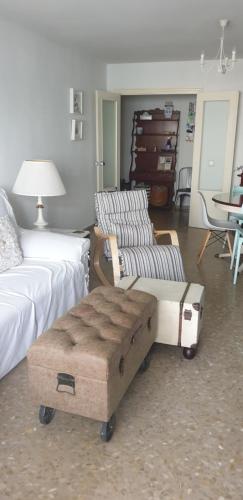 1 dormitorio con cama, sofá y mesa en Piso 110m² en el Palo con parking cerca de la playa en Málaga