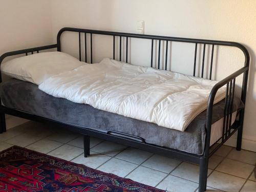 a bed with a metal frame and white sheets at Zur Sonnenblume in Gangelt