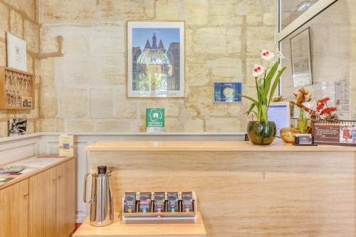 een koffiebar met een balie met een counter sidx sidx sidx bij Hôtel des Voyageurs Centre Bastide in Bordeaux