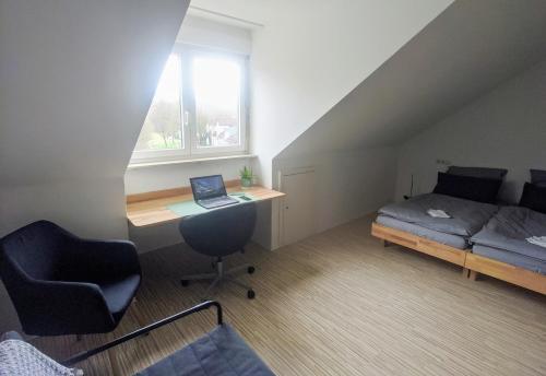 a room with a desk and a bed and a laptop at Über den Dächern von Kirchheim, Modernes Apartment in Kirchheim unter Teck