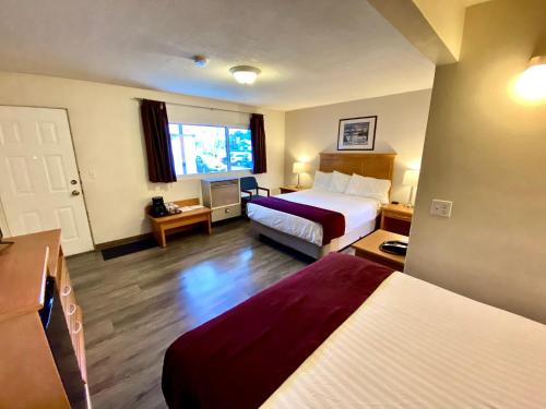 a hotel room with two beds and a window at Silver Star Motel in Vernon