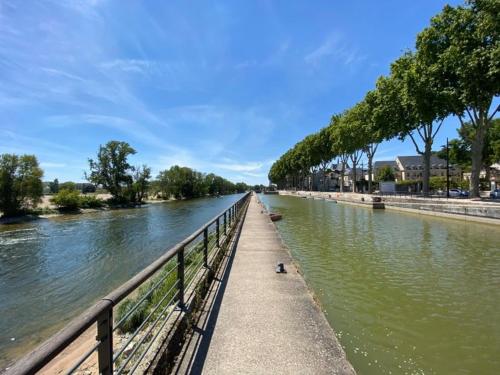 une rivière avec une clôture à côté de l'eau dans l'établissement Temps de voyage, centre d'Orléans, à Orléans