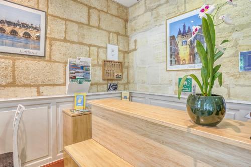 a shop with a flower vase on a counter at Hôtel des Voyageurs Centre Bastide in Bordeaux