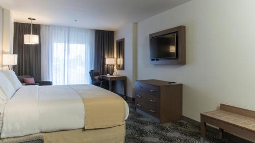 a hotel room with a bed and a flat screen tv at Holiday Inn Express & Suites Chihuahua Juventud by IHG in Chihuahua