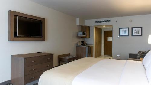 a hotel room with a large bed and a flat screen tv at Holiday Inn Express & Suites Chihuahua Juventud by IHG in Chihuahua