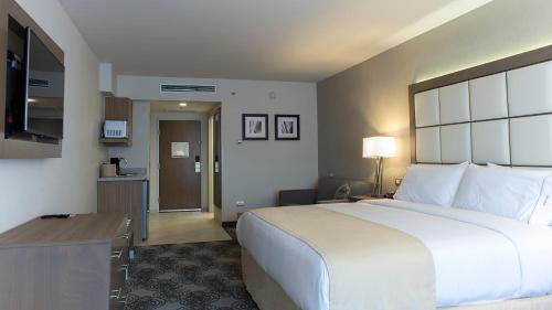 a hotel room with a large bed and a kitchen at Holiday Inn Express & Suites Chihuahua Juventud by IHG in Chihuahua