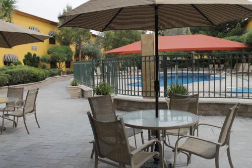 a table and chairs with an umbrella next to a pool at Holiday Inn Express Chihuahua by IHG in Chihuahua