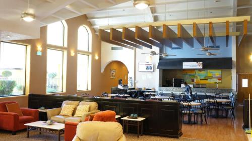 a restaurant with a bar and tables and chairs at Holiday Inn Express Chihuahua by IHG in Chihuahua