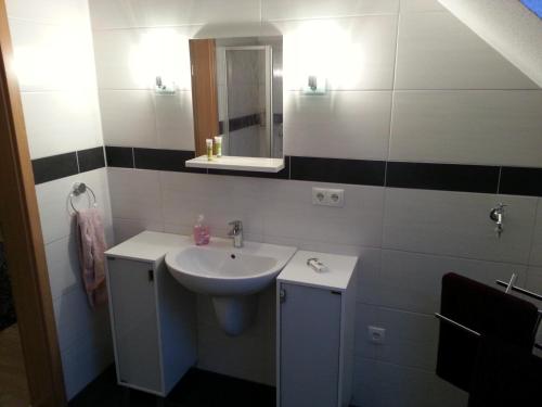 a bathroom with a sink and a mirror at ferienwohnung mertens in Westerstede