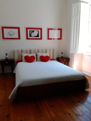 a bedroom with a large bed with two red pillows at Guest House VC17 in Sintra
