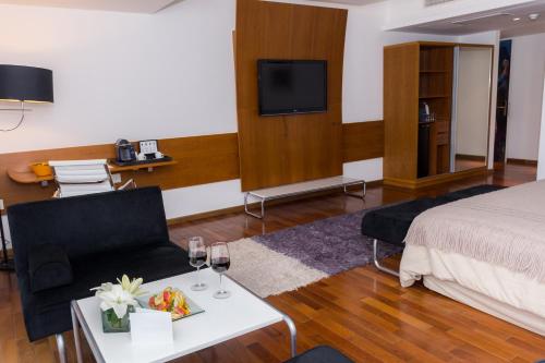 a hotel room with a bed and a tv at Design Suites Buenos Aires in Buenos Aires
