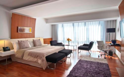 a bedroom with a large bed and a living room at Design Suites Buenos Aires in Buenos Aires