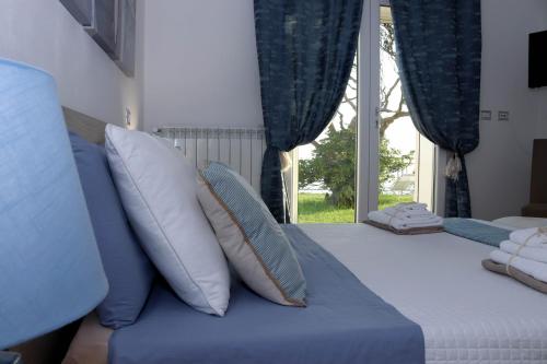 a bedroom with a blue bed with pillows and a window at Sunset House in Anzio