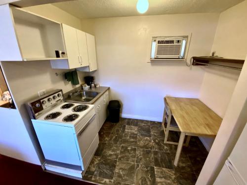 a small kitchen with a stove and a table at Silver Star Motel in Vernon