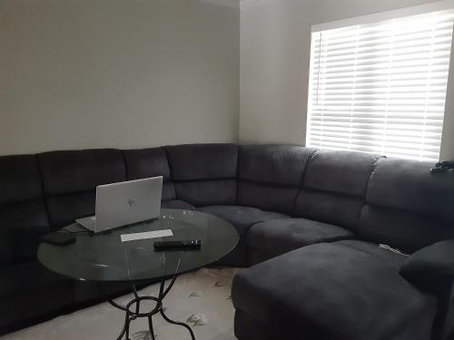 a living room with a couch and a table with a laptop at Lovely oasis with private swimming pool 4,6,8 f deep in Gulf Breeze