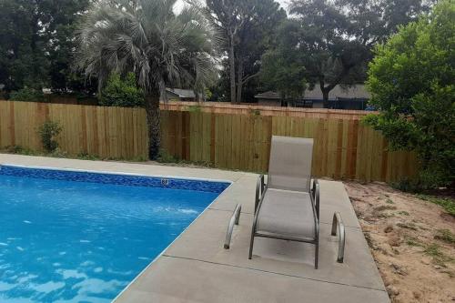 a chair sitting next to a swimming pool at Lovely oasis with private swimming pool 4,6,8 f deep in Gulf Breeze