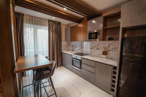 cocina con encimeras de mármol, mesa y fogones en Haris Luxury Apartment no.4, en Tirana