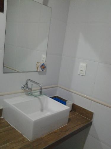 a bathroom with a white sink and a mirror at Exclusive Guest House - Suites Charmosas na Vila in Porto De Galinhas