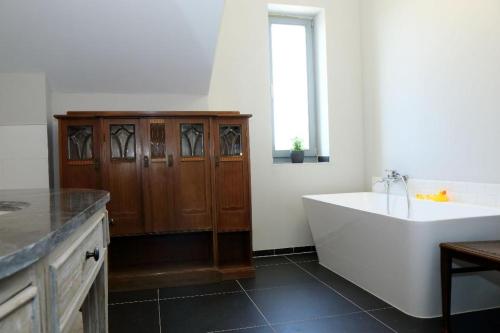 a bathroom with a tub and a sink and a window at Apartment in Buchholz